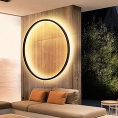 a living room filled with furniture next to a wall mounted circular light on the wall