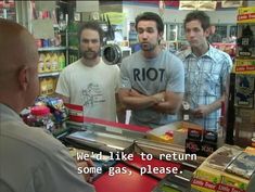 three men standing in a store talking to each other