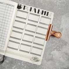 an open planner sitting on top of a table next to a pair of scissors and a clipboard