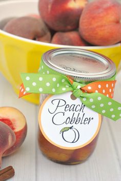 peach cobbler in a jar next to apples and cinnamon sticks