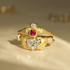 A ruby and diamond perched in a pair of tiny hands. Gold Heart Engagement Ring, Ruby And Diamond Ring Engagement, Vintage Heart Engagement Rings, Vintage Heart Ring, Heart Ring Gold, Sacred Heart Engagement Ring, Vintage 14k Gold Heart Ring, Statement Ring, Anthony Lent Rings