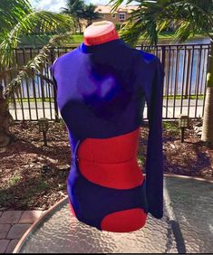 a blue and red bodysuit sitting on top of a table next to a palm tree