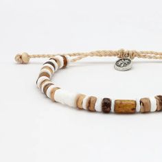 Introducing the Nusa Lembongan Wood Bead Bracelet! Inspired by the coconut trees surrounding Nusa Lembongan in Bali! Designed as a surf-inspired addition to your anklet stack, this anklet will keep a piece of the beach with you everywhere you go! Made with dyed coconut wood, natural shell and a wax polyester cord. Measures approx. 17cm with a 7cm sliding knot extension. Handmade in Bali. Biodegradable or recyclable packaging. Heishi Beads Jewelry With Sliding Knot For Beach, Beach Jewelry With Heishi Beads And Sliding Knot, Hippie Brown Beaded Bracelets For Beach, Beach Wooden Beads Friendship Bracelets, Adjustable Wooden Beads Friendship Bracelets For Beach, Beach Friendship Bracelets With Round Wooden Beads, Adjustable Wooden Beads Friendship Bracelets, Brown Heishi Beads Bracelets For Beach, Casual Heishi Beads Bracelets For Vacation