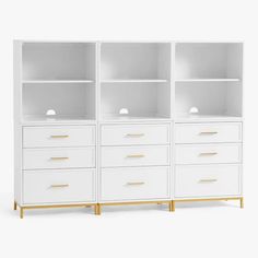 a white bookcase with gold handles and drawers on the bottom, against a white background