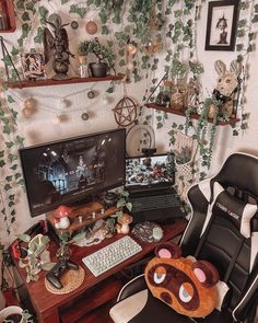 a desk with a computer, mouse and stuffed animal on it in front of a plant wall