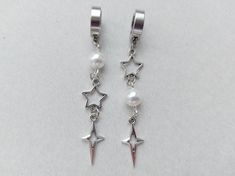 The earrings are decorated with white faux pearl beads. Silver-colored brass pendants in the shape of stars are attached to the earrings. These earrings are without ear piercing The earrings are fastened with stainless steel clips. Earring length - 7.0 cm (2.8 inches) Earrings  are packed in a gift box RECOMMENDATIONS FOR CARE: Do not wet, do not drop, and store in a dark box! - Remove jewelry before exercising, swimming, showering and sleeping. - Avoid contact with moisture such as make-up, moi Y2k Accessories Earrings, Cute Star Earrings, Piercings Goth, Alt Jewelry, No Piercing Earrings, Star Clips, Earrings No Piercing, Brass Pendants, Korean Earrings