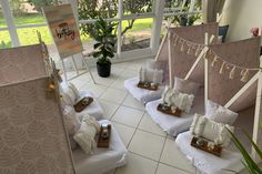 a room filled with lots of pillows on top of white flooring next to a window