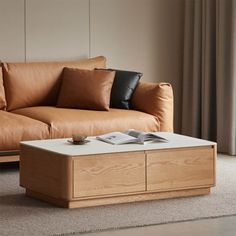 a brown leather couch sitting next to a wooden coffee table on top of a carpeted floor