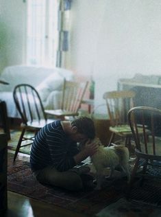 a man sitting on the floor with his dog