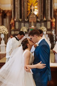 a bride and groom kissing in front of the alter