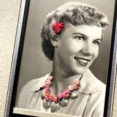 an old black and white photo of a woman wearing a necklace