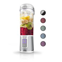 a blender filled with fruit and vegetables on top of a white table next to five different colors