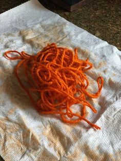 a pile of orange yarn sitting on top of a white towel