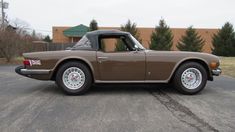 a brown sports car parked in a parking lot