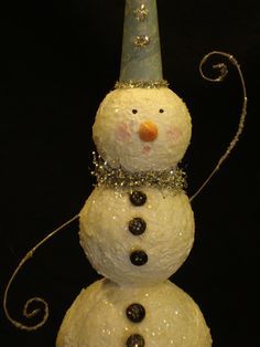 a snowman with a blue hat on top of it