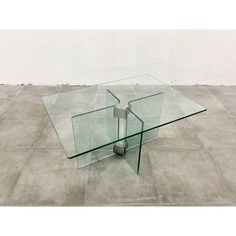 a glass table sitting on top of a cement floor