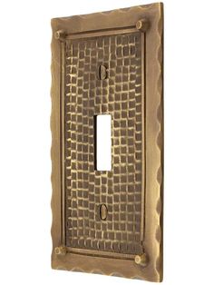 a decorative light switch plate cover in gold metal with an intricate design on the front