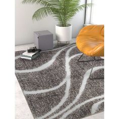 a modern rug with an abstract design in grey and white, next to a yellow chair