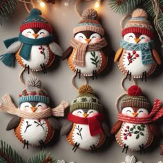 four snowman ornaments hanging from a christmas tree