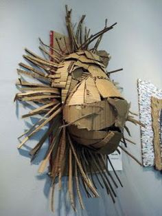 a sculpture made out of cardboard sitting on top of a wall