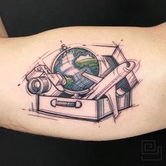 a tattoo with an airplane and globe on it