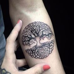 a woman's arm with a tree tattoo on it