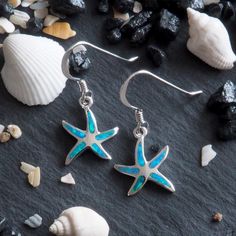 Beautiful Aqua Colored Synthetic Opal Inlay Sterling Silver Rhodium Plated For Superior Finish And Anti-Tarnish Properties Includes Black Pouch And Black Jewelry Box A Beautiful And Unique Hawaiian Gift Darling starfish earrings with blue synthetic opal inlay and post backing. Starfish measures 1/2 inch tall and 7/16 inch (0.44 inch) wide. Rhodium plated sterling silver for superior quality and shine as well as anti-tarnish properties.Please note, the picture shown is not a true depiction of how Black Jewelry Box, Hawaiian Gifts, Black Pouch, Wave Ring, Synthetic Opal, Black Jewelry, Aqua Color