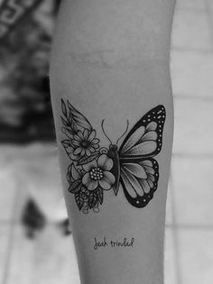 a black and white photo of a butterfly with flowers on it's side leg