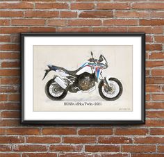 a motorcycle is hanging on the wall next to a brick wall with a black frame