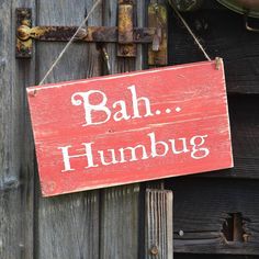 a red sign that says bah humbug hanging from a wooden door frame