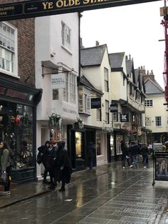 people are walking down the street on a rainy day