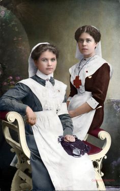 two women dressed in historical clothing posing for a photo