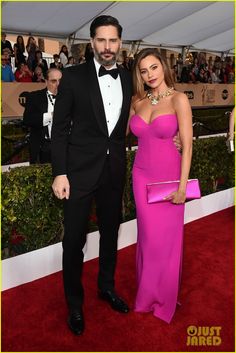 a man in a tuxedo standing next to a woman in a pink dress