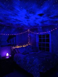 a bedroom with blue lights on the ceiling and stars in the night sky above it