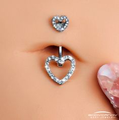 a pair of heart shaped piercings on the side of a woman's stomach