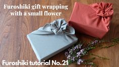 two wrapped gift boxes sitting on top of a wooden floor next to a bouquet of flowers