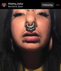 a woman with piercings on her nose and nose ring in front of her face