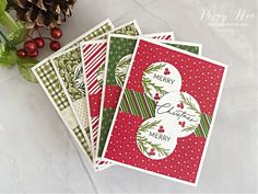 three christmas cards with pine cones and evergreens on them, sitting next to each other