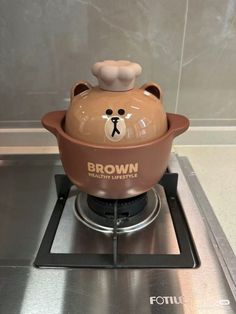 a brown bear pot sitting on top of a stove