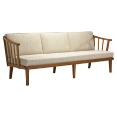 a wooden couch with white cushions on it