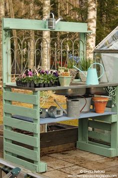 an outdoor garden bench with potted plants on it