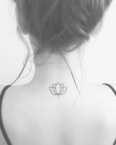 the back of a woman's neck with a lotus tattoo on it