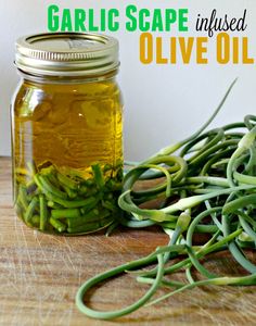 a jar filled with green beans sitting on top of a wooden table next to a pile of sprouts