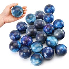 blue marbles are being held by a person's hand on a white background