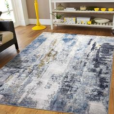 a blue and white rug in the middle of a living room with yellow accents on it