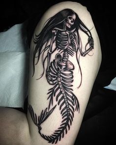 a woman with a skeleton tattoo on her thigh