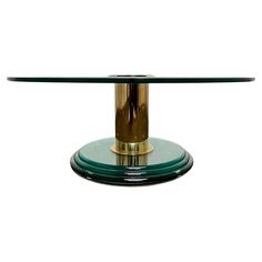 a glass table with a gold base on it