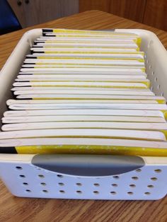 a plastic container filled with files on top of a wooden table