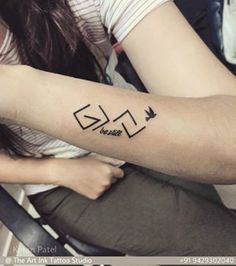 a woman with a tattoo on her arm that reads glo and has an arrow