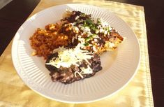 a white plate topped with rice and meat covered in grated parmesan cheese